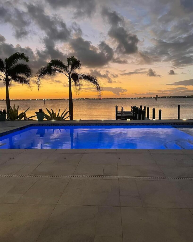 Blue lite pool with an amazing ocean landscape behind it. blue lighting