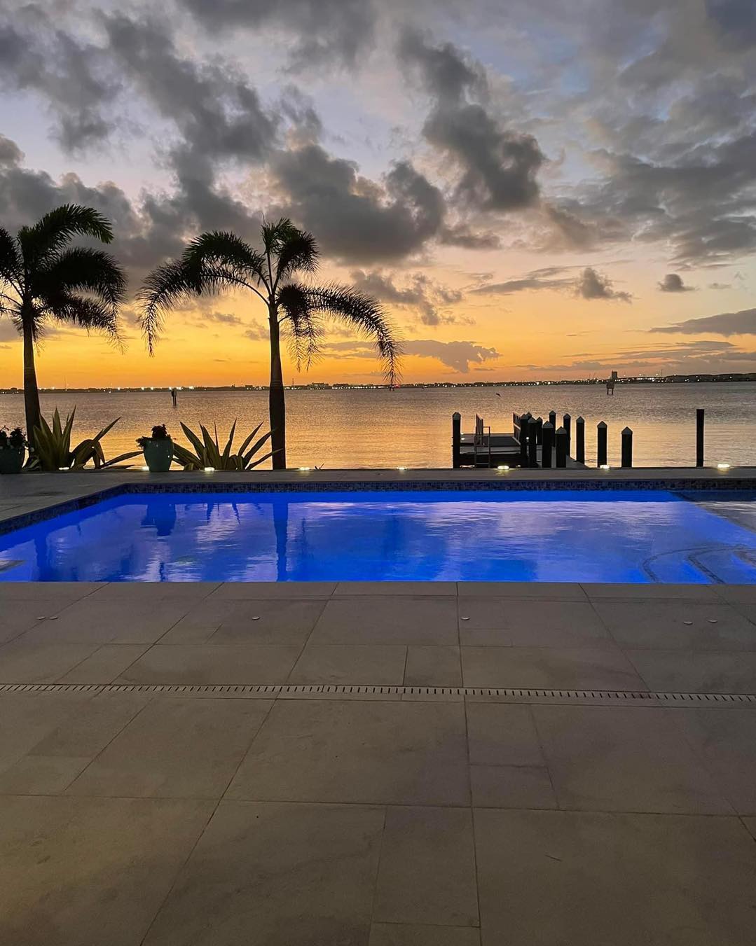 Blue lite pool with an amazing ocean landscape behind it. blue lighting